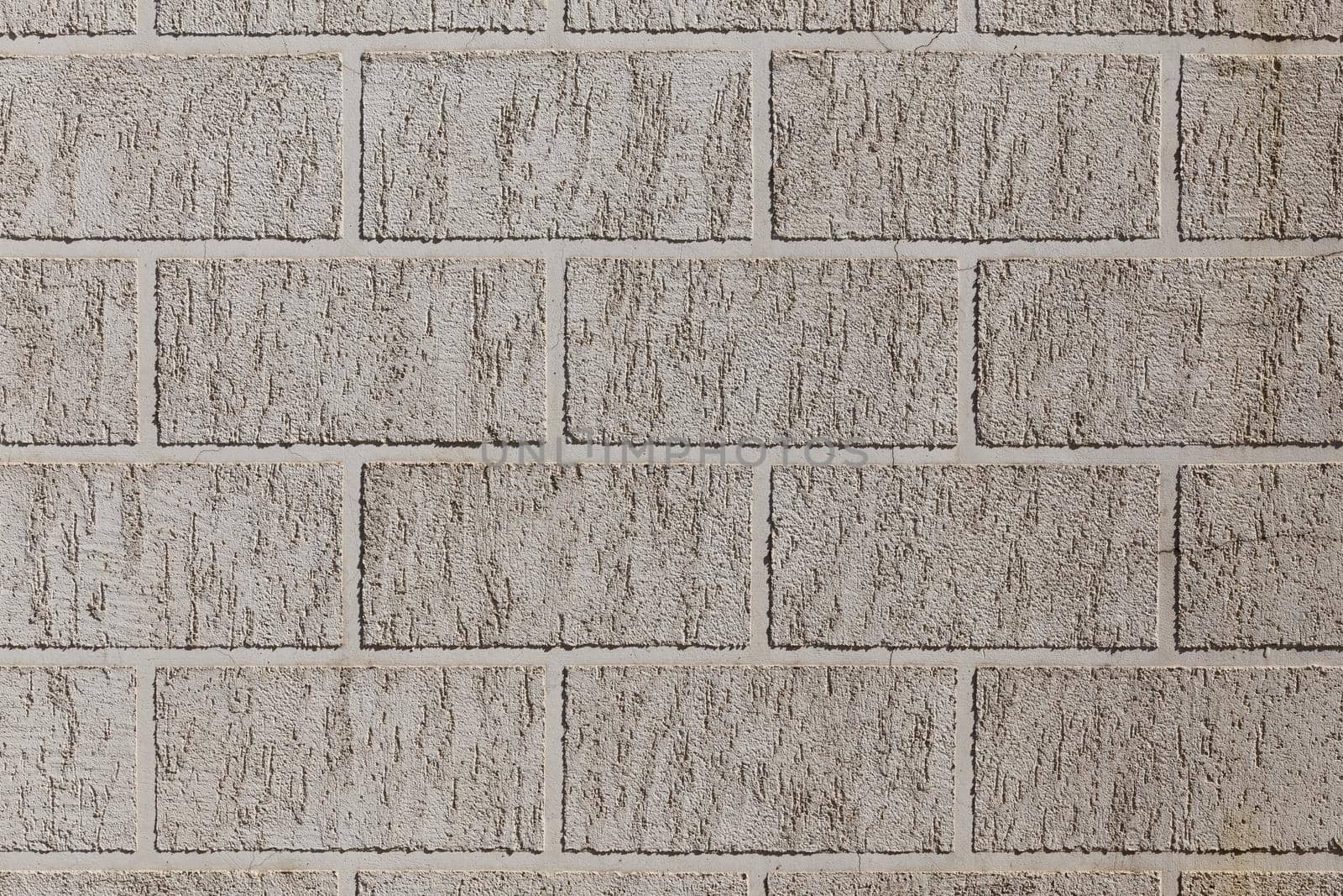 artificial brick-like pattern embossed in flat plaster surface.