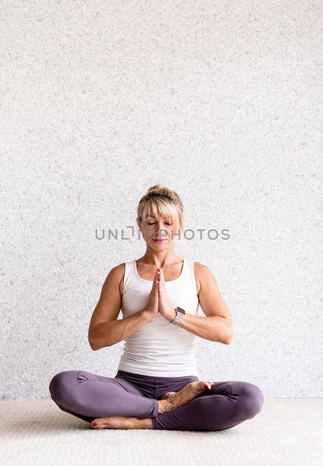 attractive woman practicing yoga at home by Desperada