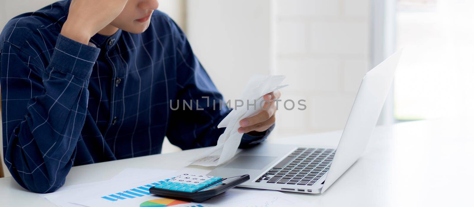 Young asian man calculating expenses household about finance and frustrated on desk at home, male checking bill having stress and worried, debt and tax, expression and emotion, business concept.