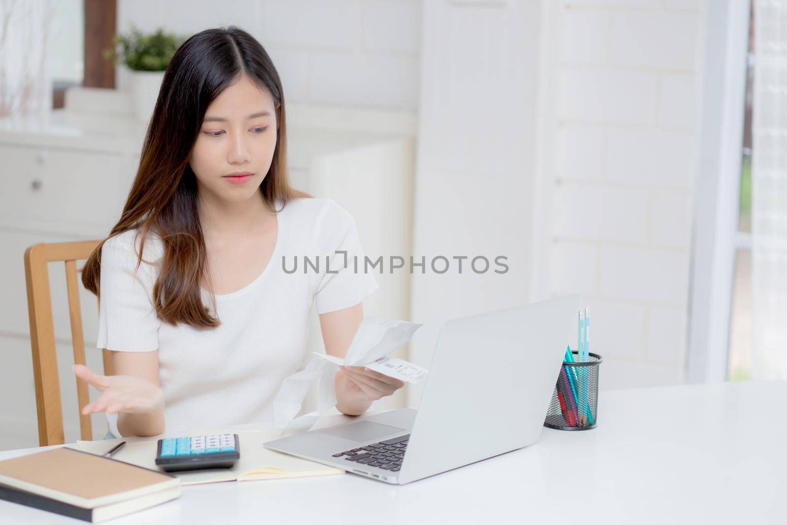 Young asian woman calculating expenses household about finance and frustrated on desk at home, girl checking bill having stress and worried, debt and tax, expression and emotion, business concept.