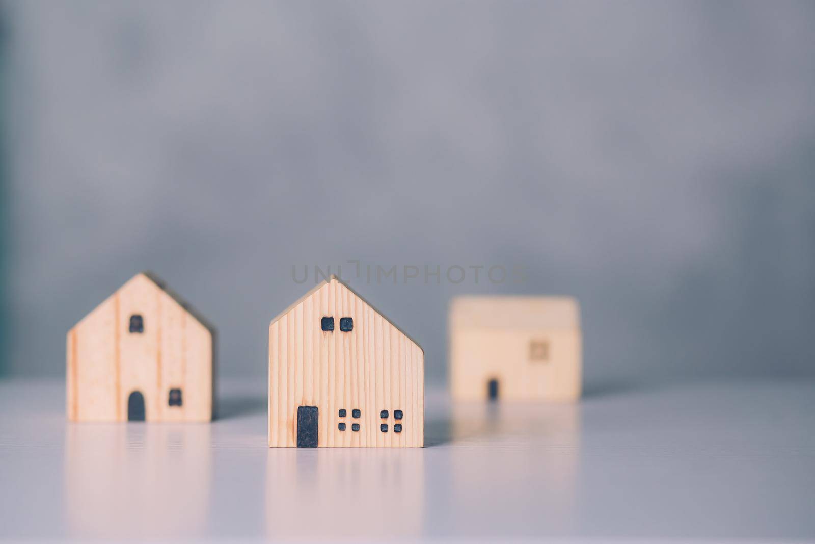 Mini wooden home model concept, investment of real estate and asset, tax of property and rental for finance, no people, small house and inspiration, mortgage and loan for residence, business concept. by nnudoo