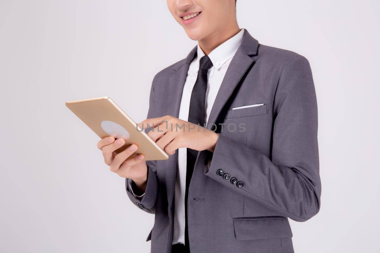 Portrait young asian business man in suit standing using tablet computer to internet isolated on white background, businessman confident touch screen digital pad with success, communication concept.