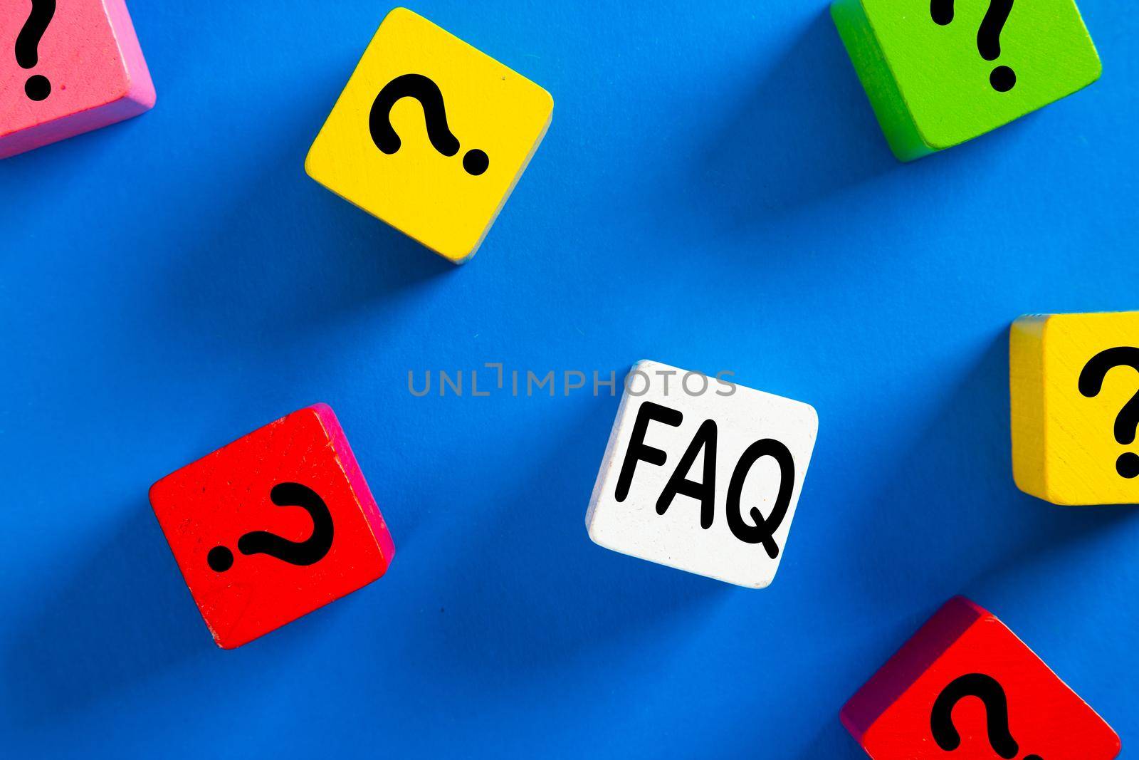 Question mark icon on blue wooden block on blue background. Q&A or FAQ concept.