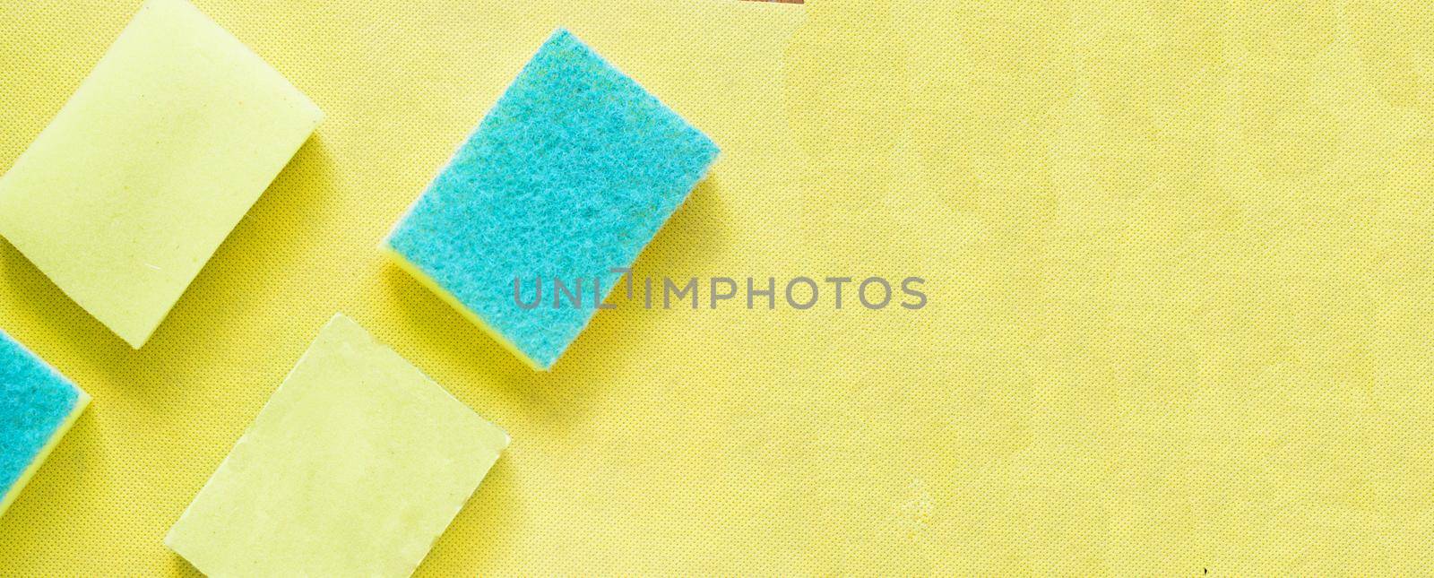 Several bright yellow sponges on yellow background.Advertising banner for cleaning.