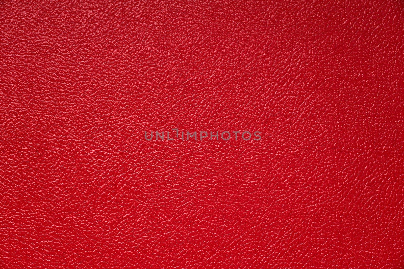 The subtle texture of red tolex on a guitar amp speaker cabinet. The vinyl covering protects the surface.