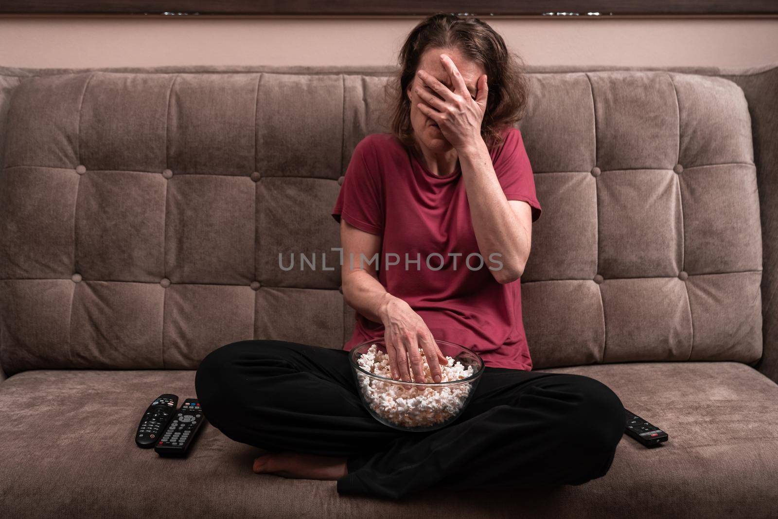 emotions when watching TV at home with popcorn. fear and awe by Edophoto