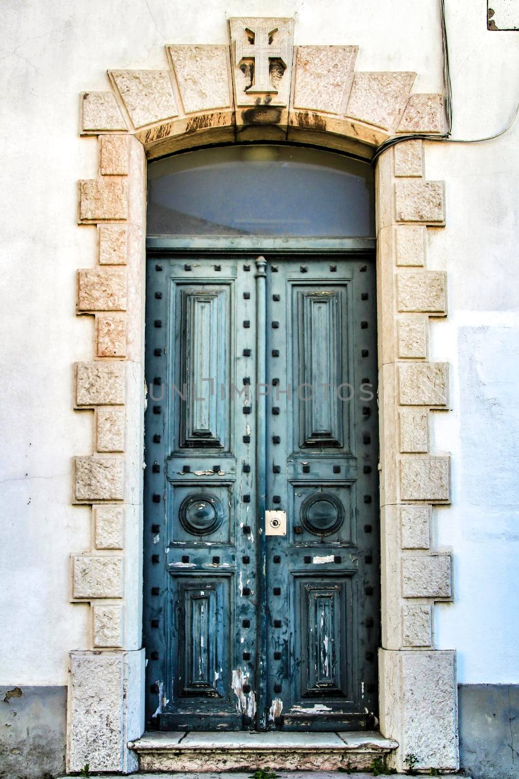 Old and colorful green wooden door with iron details in Lisbon, Portugal