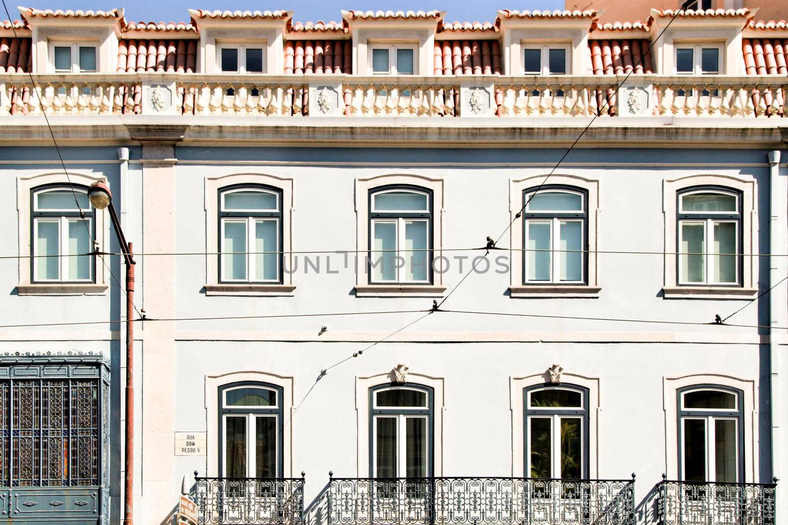 Old colorful and majestic tiled facades with vintage streetlight in Lisbon streets in Spring.