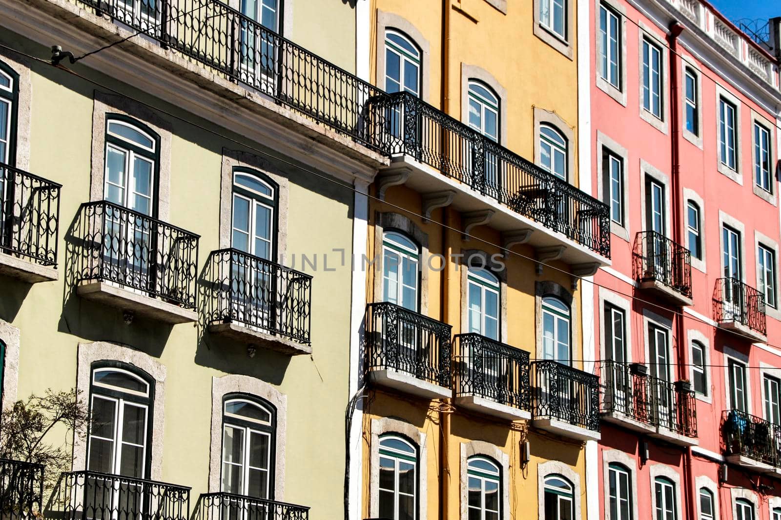 Old colorful and majestic tiled facades with vintage streetlight in Lisbon streets in Spring.