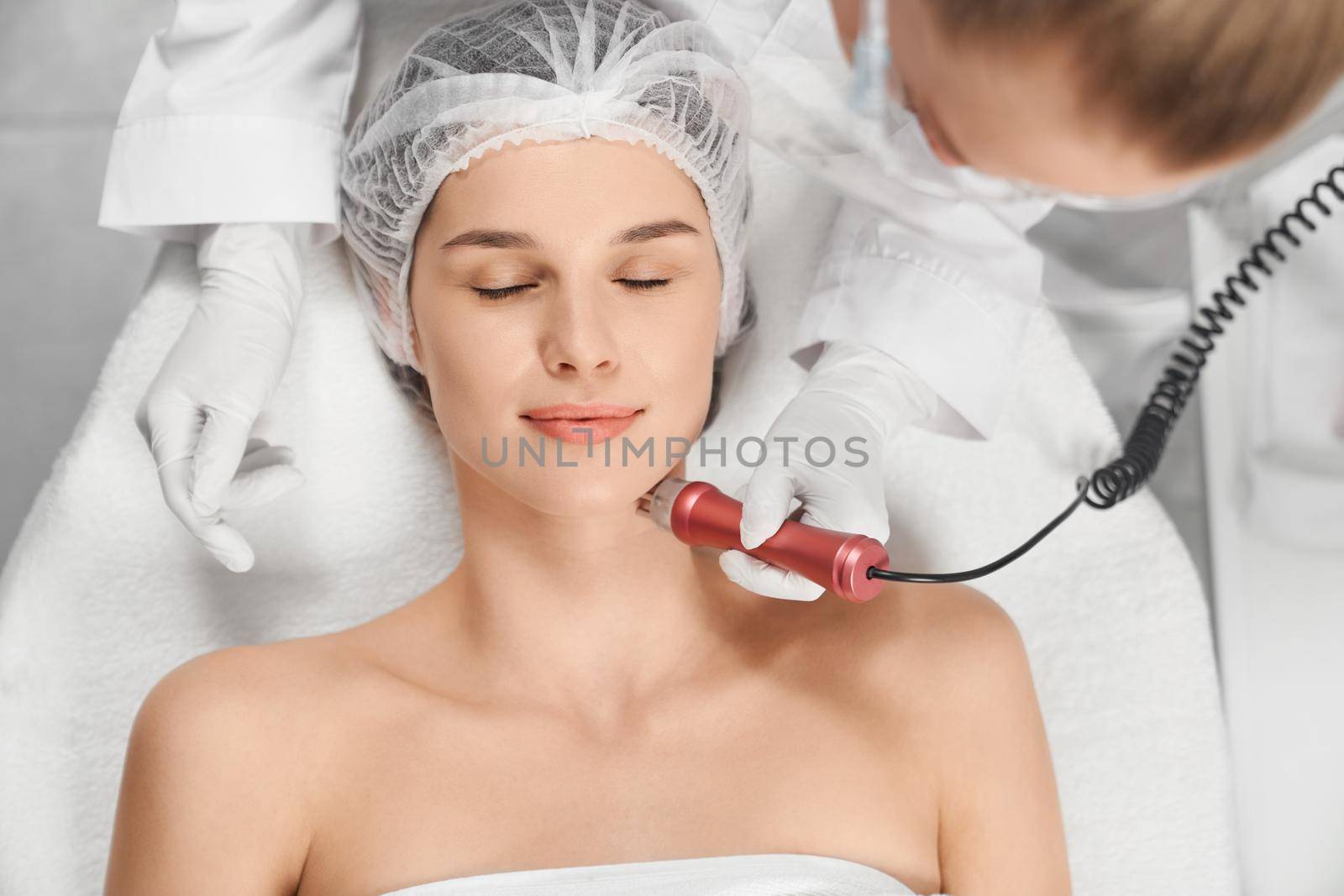 Woman enjoying procedure cleaning or massage for face. by SerhiiBobyk