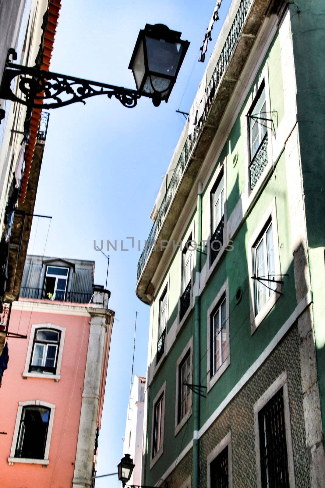 Old colorful and majestic tiled facades with vintage streetlight in Lisbon streets in Spring.