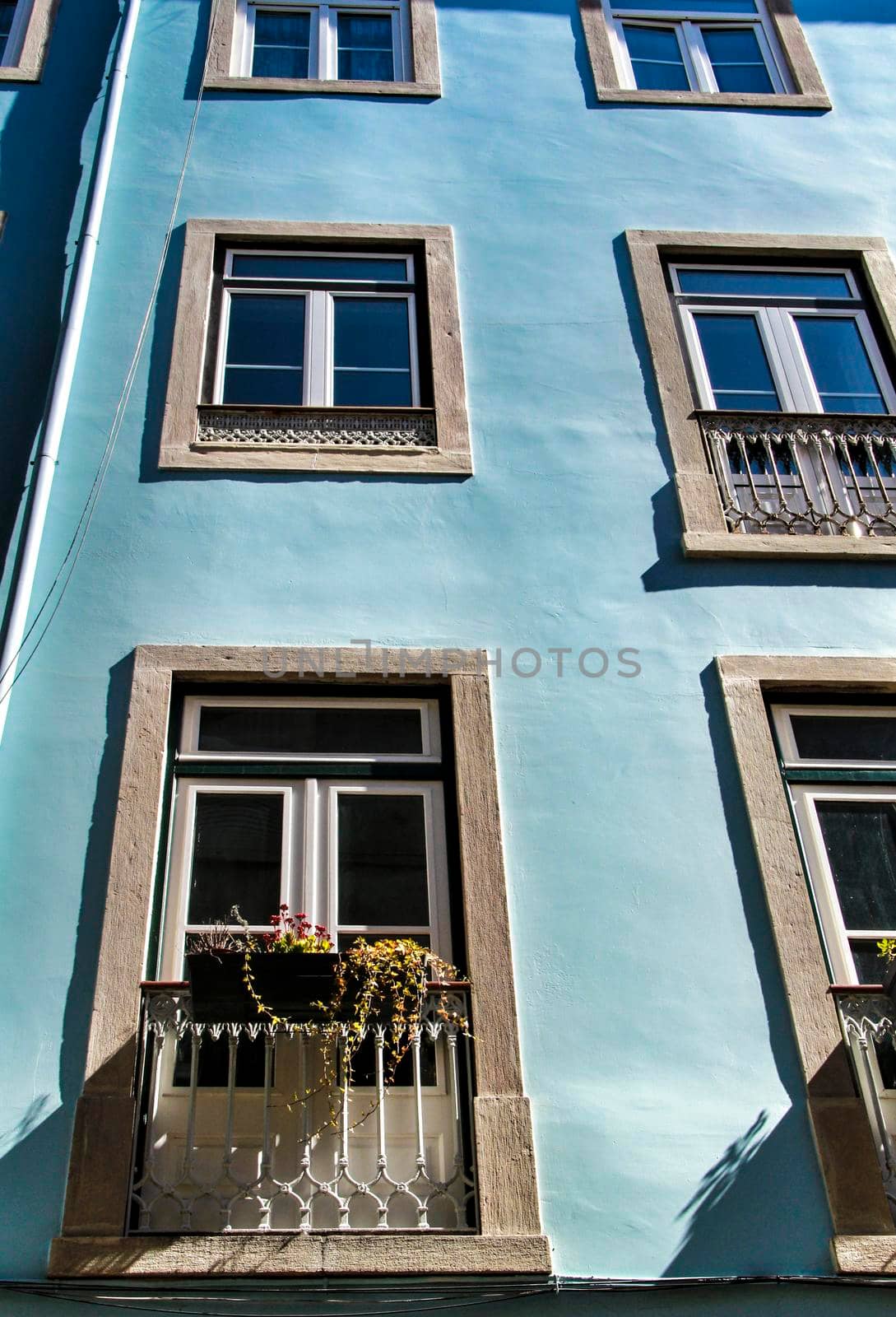 Old colorful and majestic tiled facades with vintage streetlight in Lisbon streets in Spring.