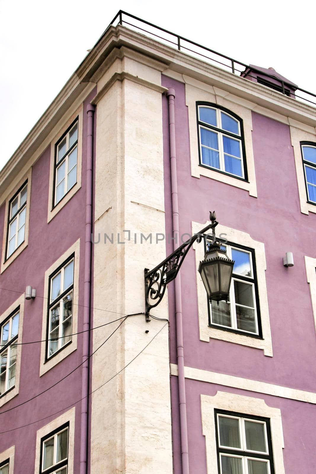 Old colorful and beautiful facades with vintage streetlight in Lisbon streets in Spring. Clothesline in the facade with hanging clothes