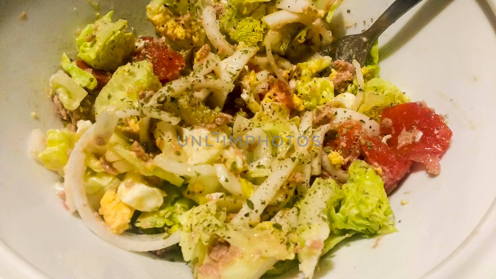 Bowl with salad garnished with oregano in the kitchen