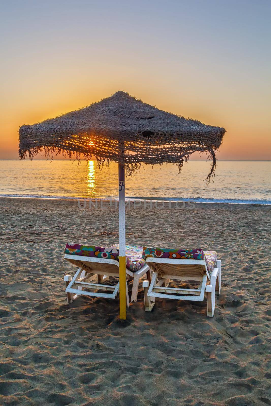 sunbed and umbrella on the sunset background, Torremolinos, Spain