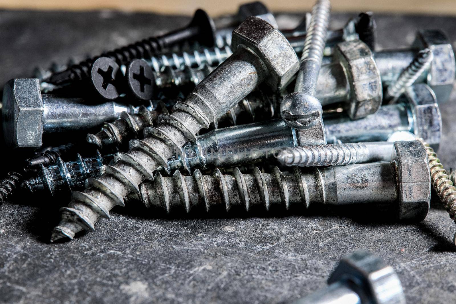 Different Kind of Screws on a table in a workshop by Weltblick