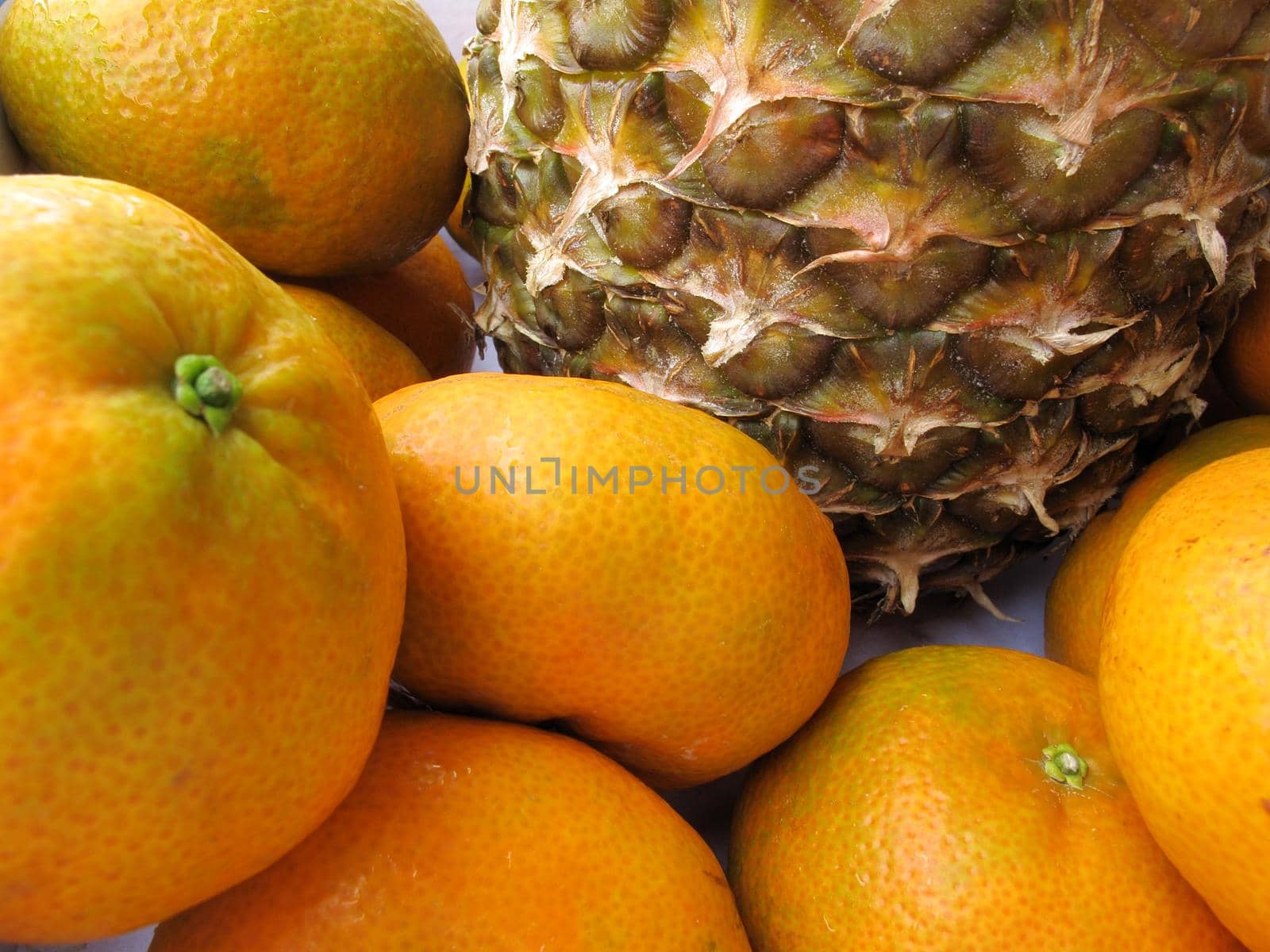 Fresh pineapple & tangerine fruit collection closeup