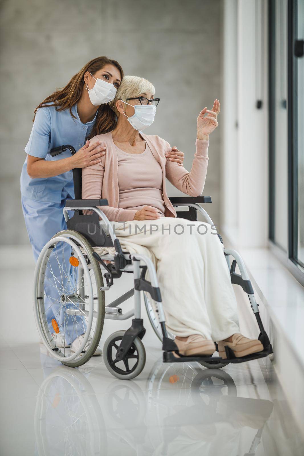 Shot of a young female nurse caring a senior female wheelchair-bound patient.