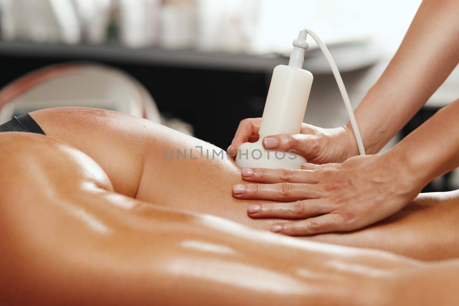 Shot of an unrecognizable woman getting anti cellulite massage at the beauty salon. She have an ultrasound cavitacion treatment to fat reduction.