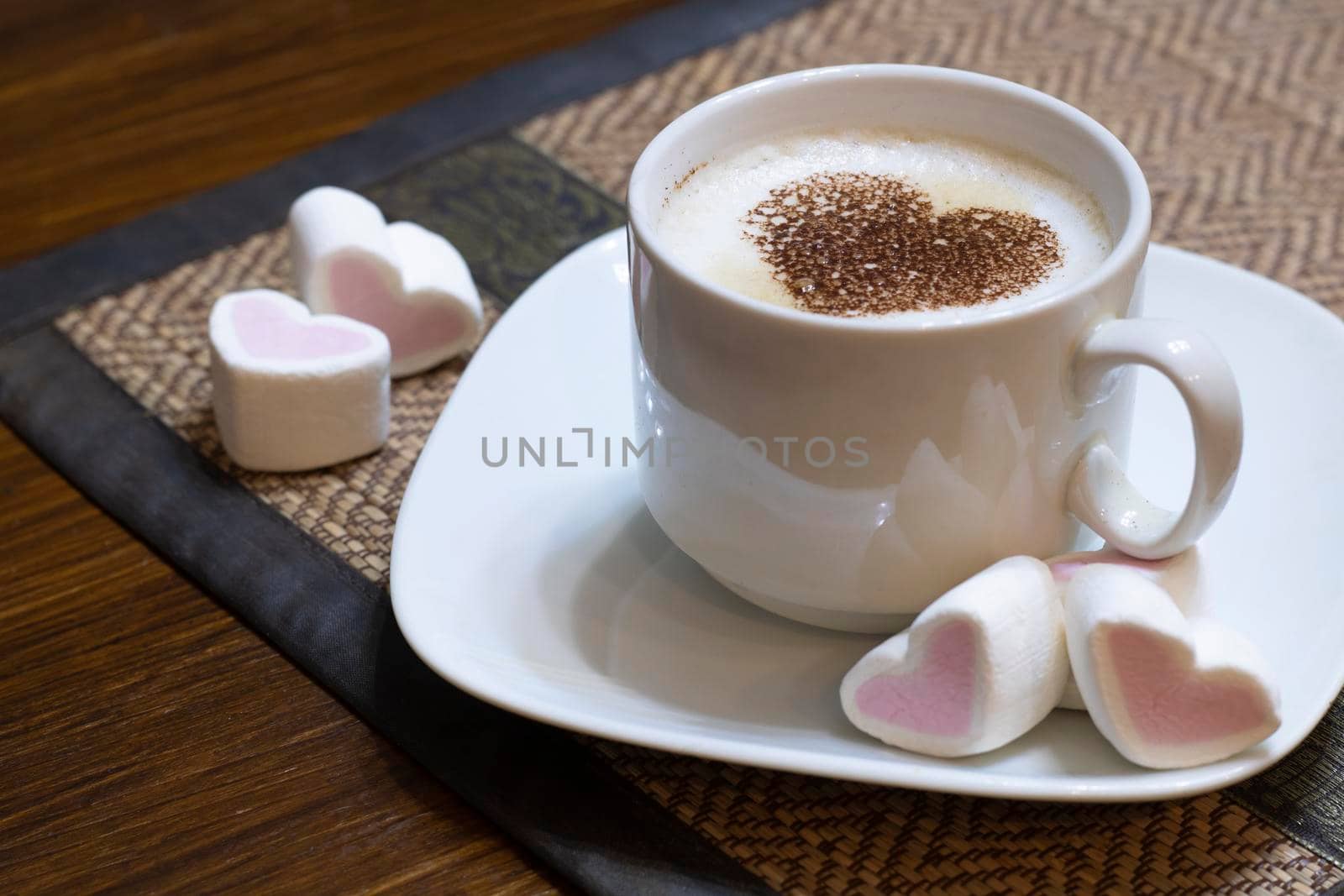 Cup of coffee with cocoa heart and sweet marshmallow hearts on the table. by Sonluna