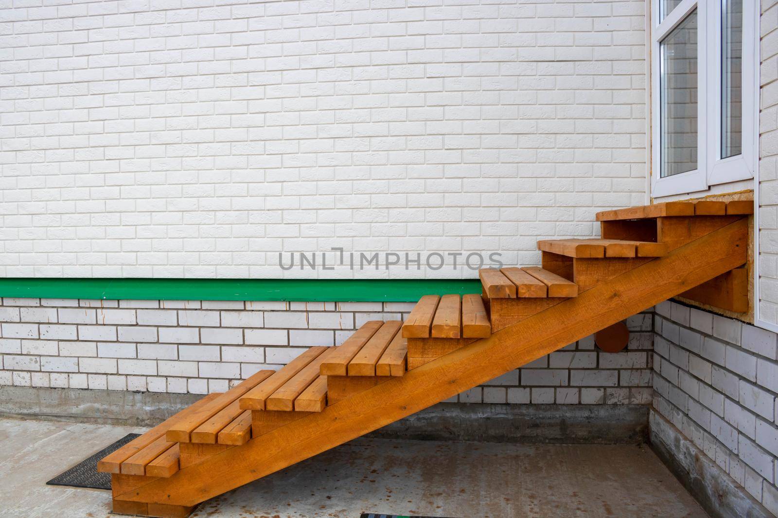 Wooden staircase painted with stain, entrance to the house.