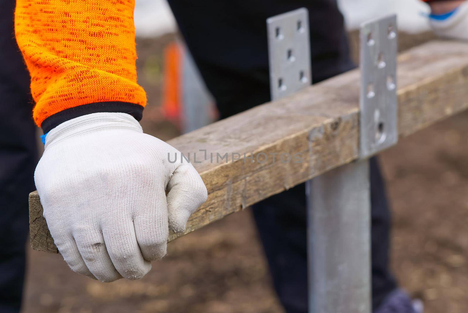 the builder twists the foundation made of screw piles. Lightweight and fast screw pile foundation is well suited for solar panels, terraces, greenhouses by PhotoTime