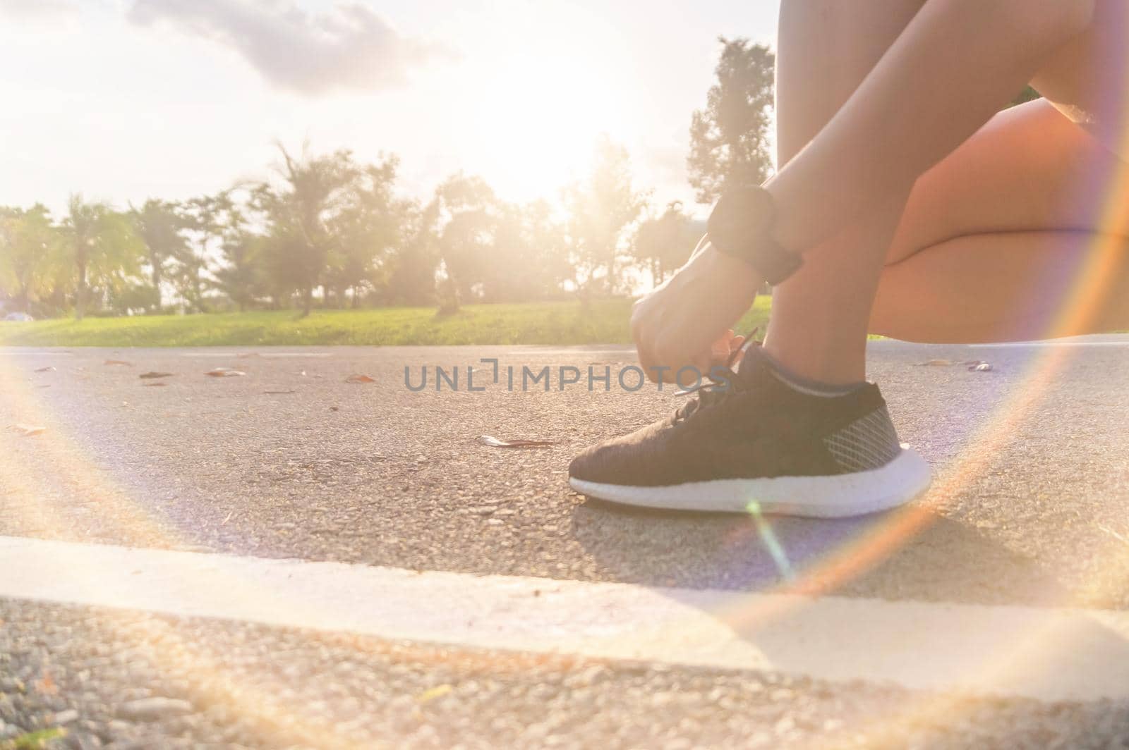 Woman wear running shoe on to walking and running on nature green background.Health exercise. by Suwant