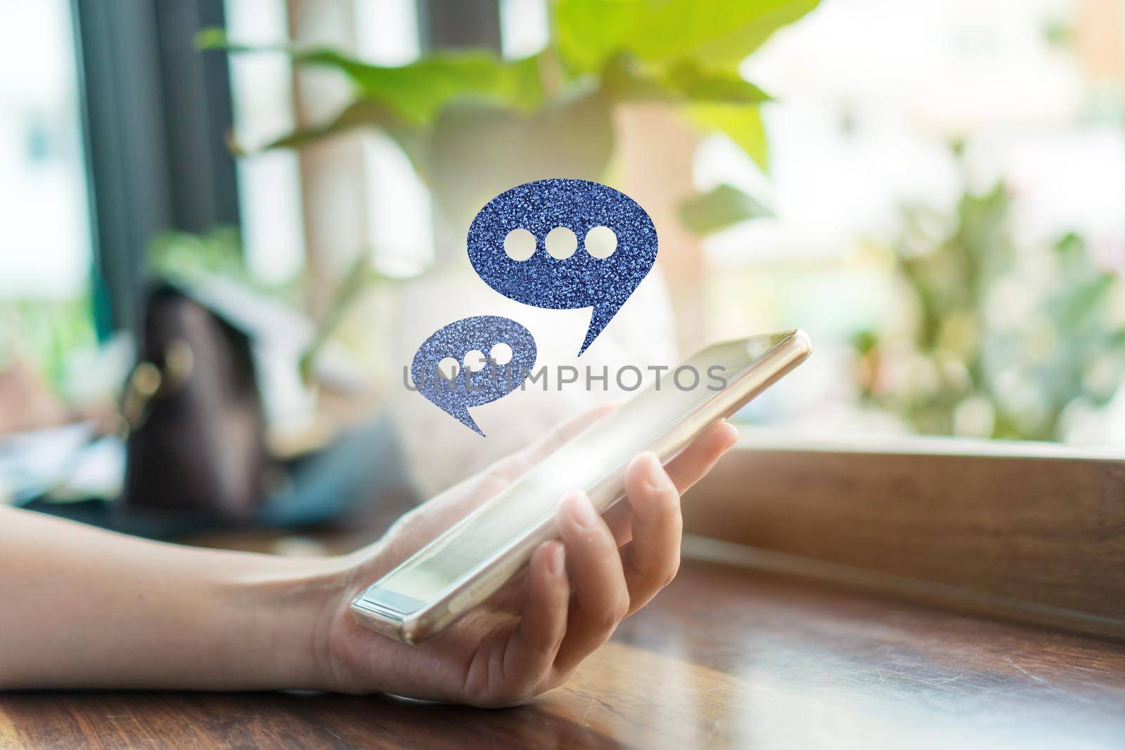 People hand using smartphone typing, chatting or text  messages in chat icons pop up. Social media maketing technology concept.  by Suwant