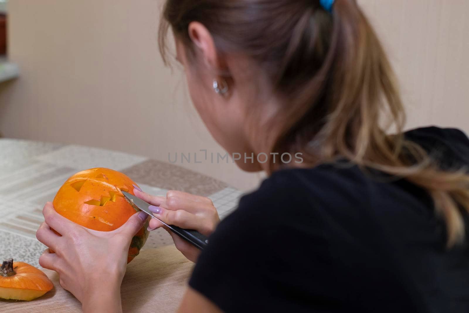 the process of making a Halloween pumpkin. cutting out the mouth by brunette girl. horror theme and Hallowe'en by oliavesna