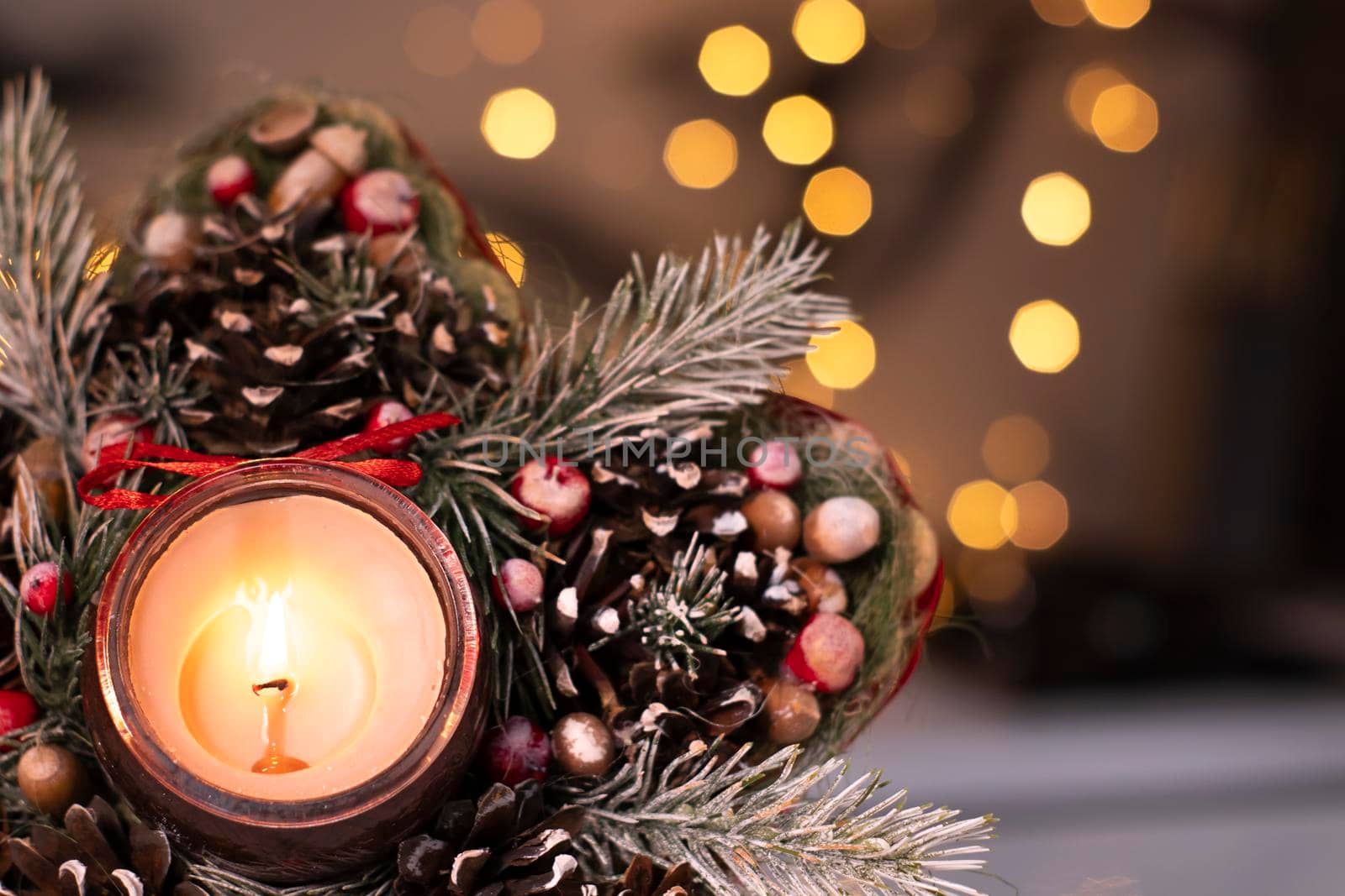 Christmas decor star-shaped made of tree branch with new years toys on it and a candle in it.