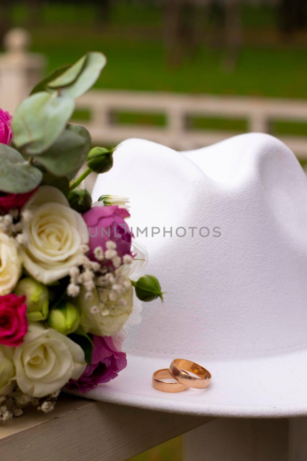 wedding rings on a white stylish hat next to the bride's bouquet. marriage concept.