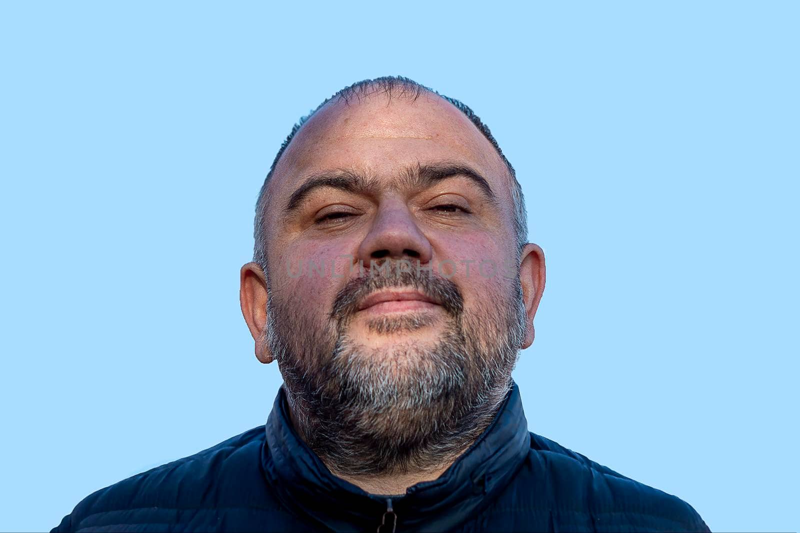 A man of 40 years with a beard on blue background. portrait. Copy space. by Essffes