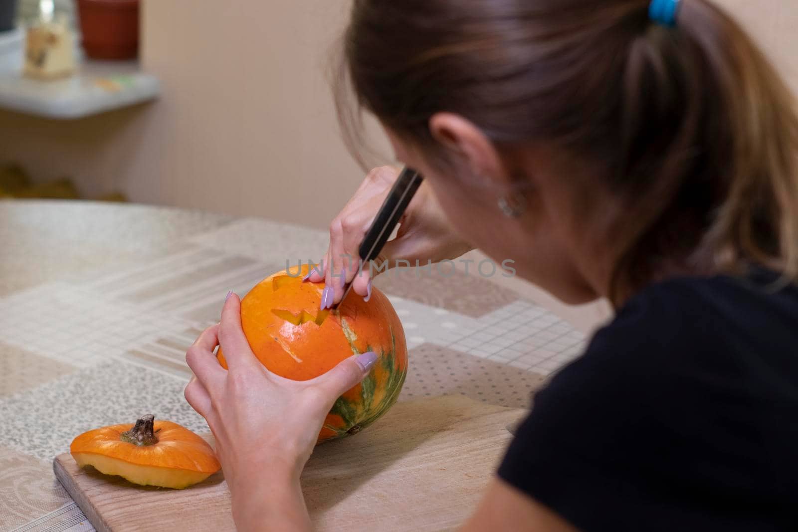 the process of making a Halloween pumpkin. cutting out the mouth by brunette girl. horror theme and Hallowe'en by oliavesna