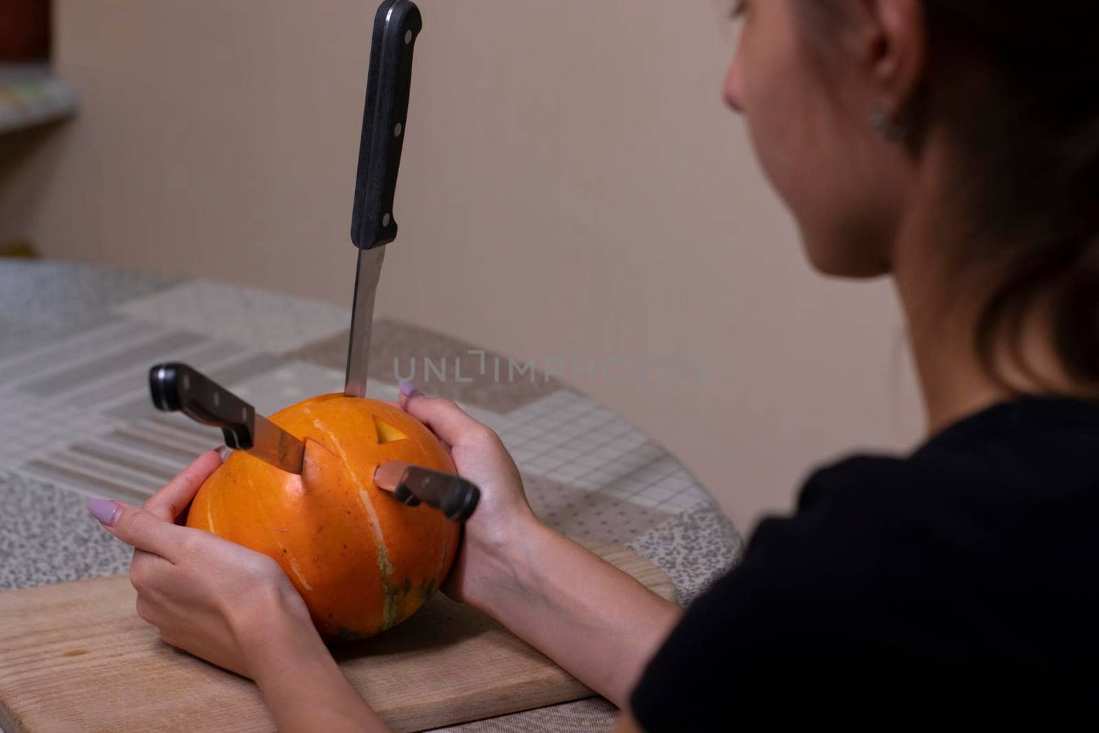 the process of making a Halloween pumpkin. knives stuck in a pumpkin. horror theme and Hallowe'en by oliavesna