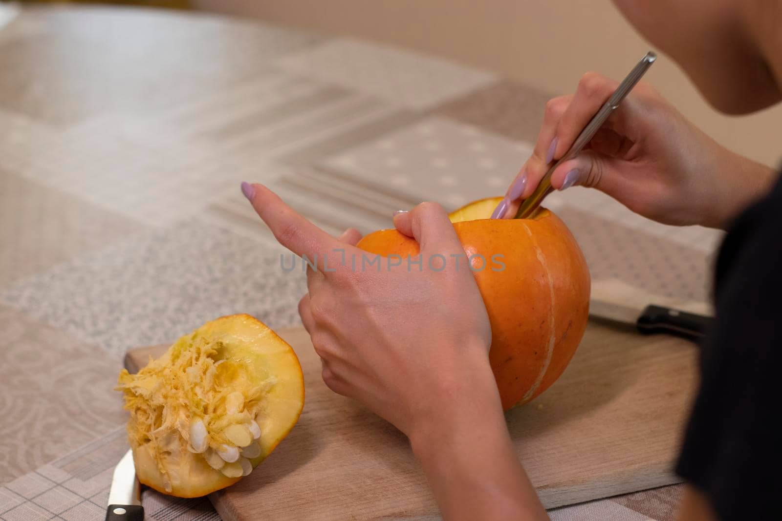 the process of making a Halloween pumpkin. cleansing of seeds by a brunette girl. horror theme and Hallowe'en.