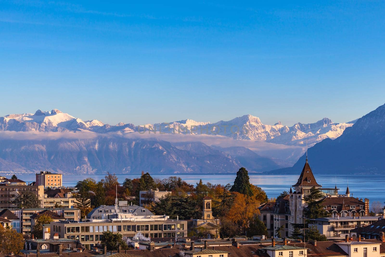 Cityscape of Lausanne with the snow covered Alps and the Leman lake in the background, Canton of Vaud, Switzerland