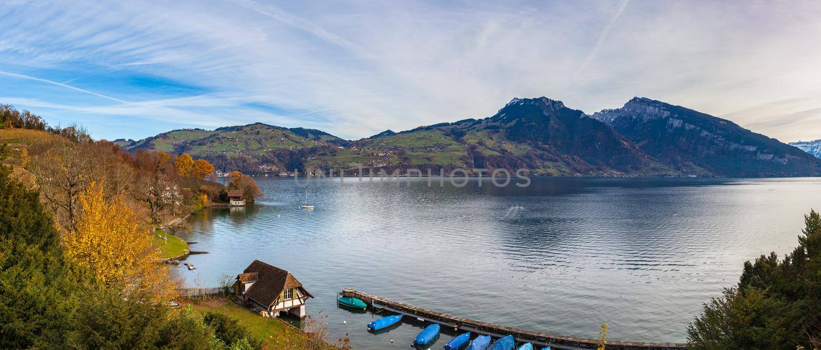 Stunning panorama view of Lake Thun from Spiez with Swiss Alps Sigriswiler Rothorn and  Niederhorn in background on a sunny autumn day with golden trees and leaves, Bernese Oberland, Switzerland by VogelSP