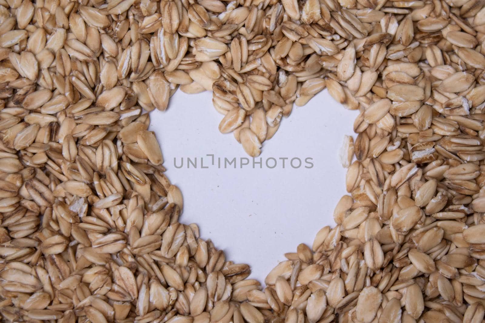 oatmeal texture with a heart painted in the middle on a white background. oat flakes. Healthy breakfast concept. Muesli cereals