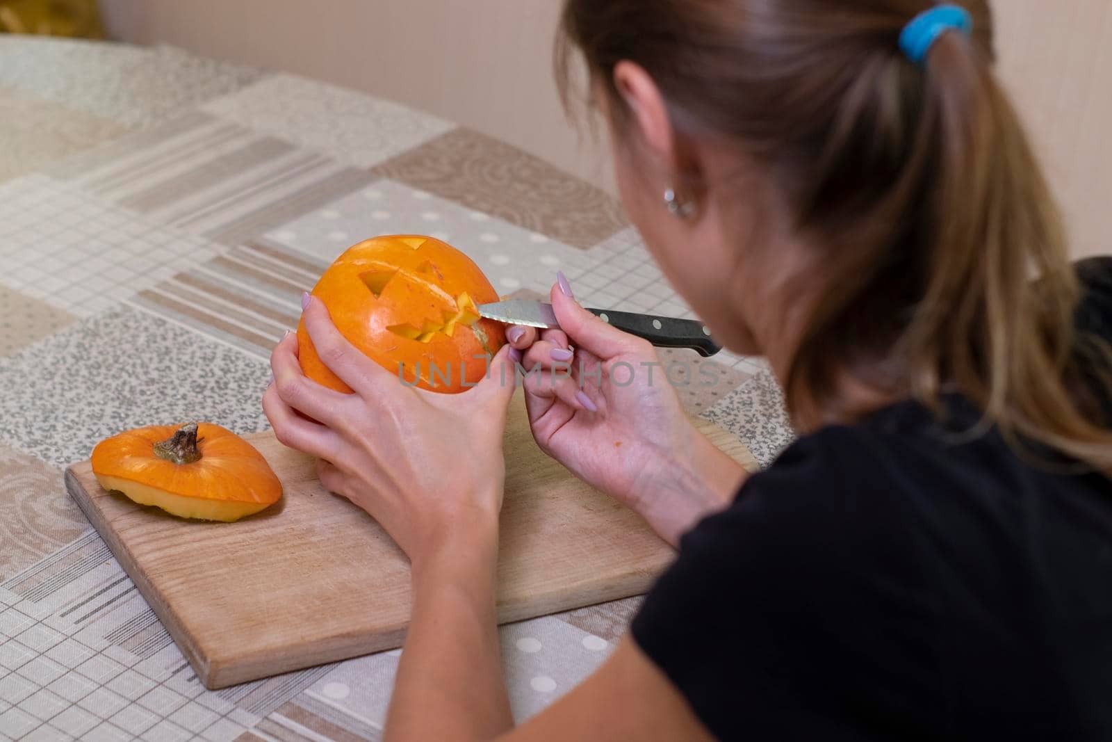 the process of making a Halloween pumpkin. cutting out the mouth by brunette girl. horror theme and Hallowe'en by oliavesna