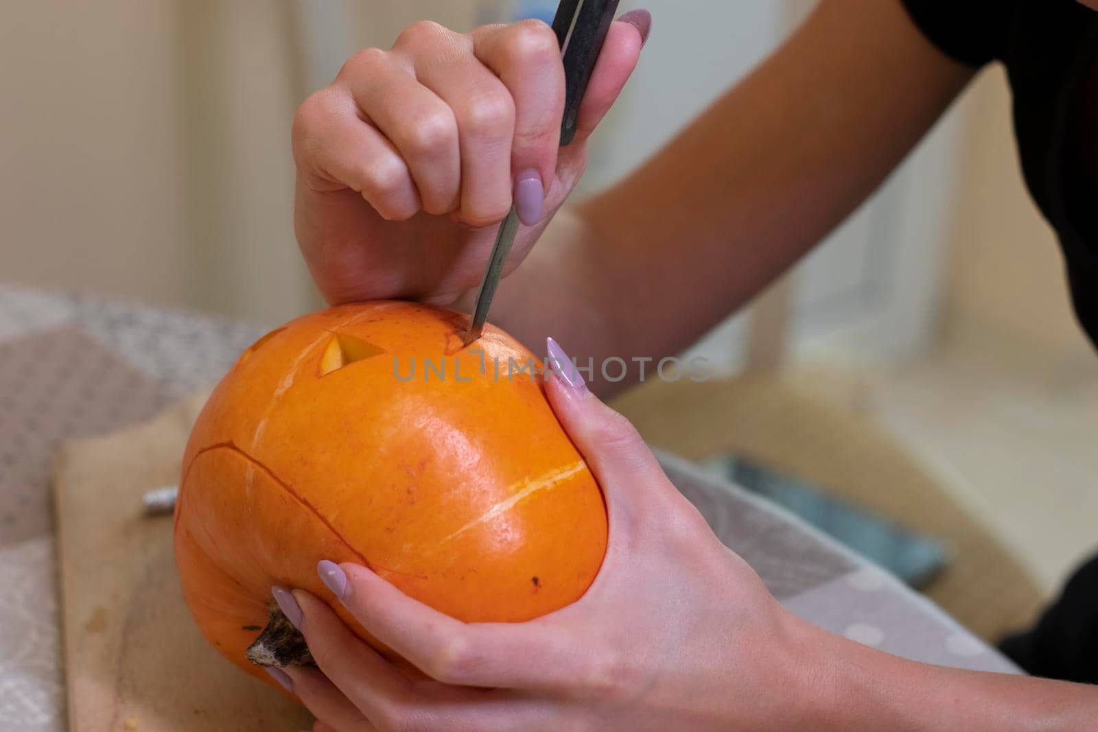 the process of making a Halloween pumpkin. cutting out the mouth. horror theme and Hallowe'en by oliavesna