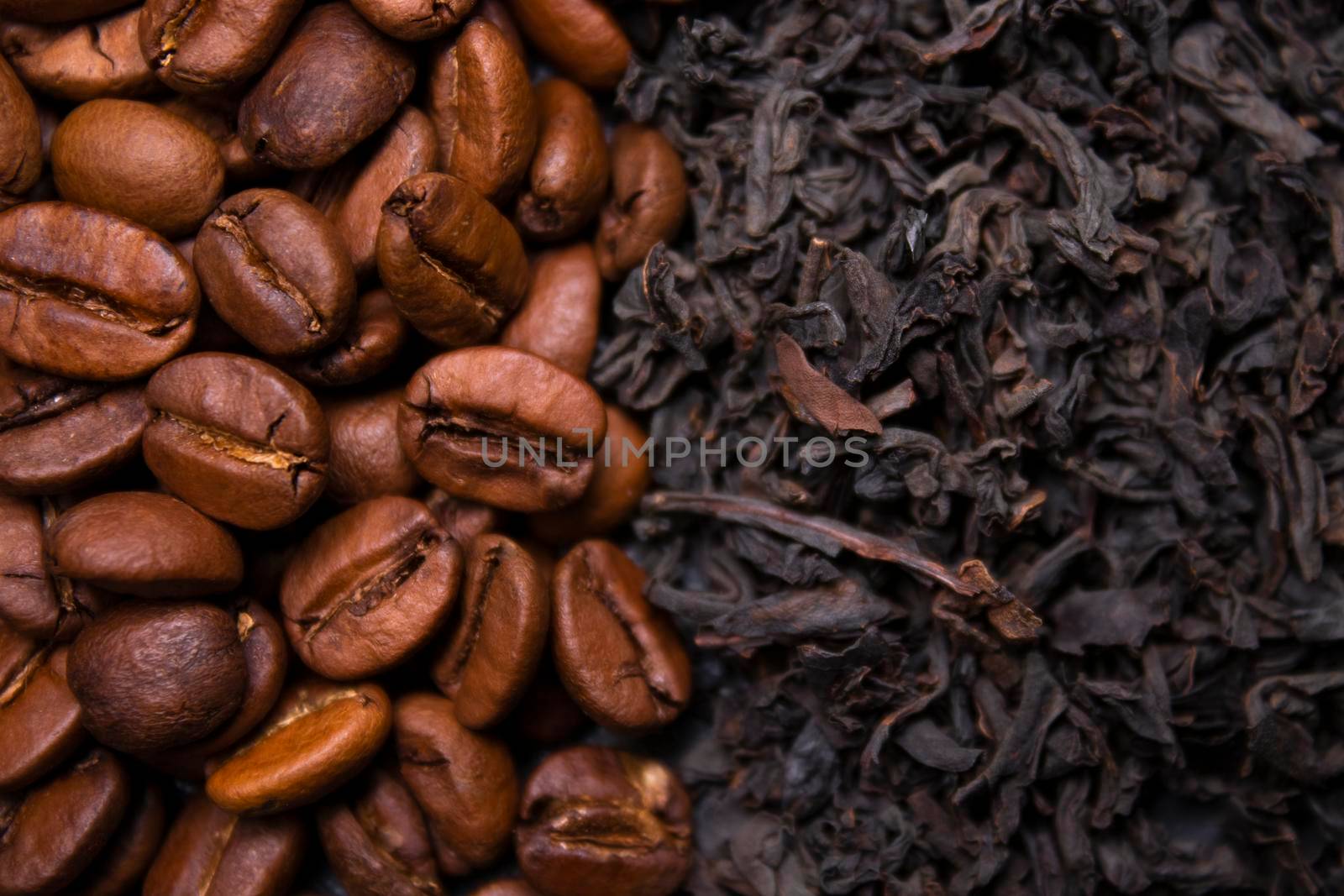 pile stack of dried tea leaves and roasted coffee beans seeds: theine vs caffeine. background .