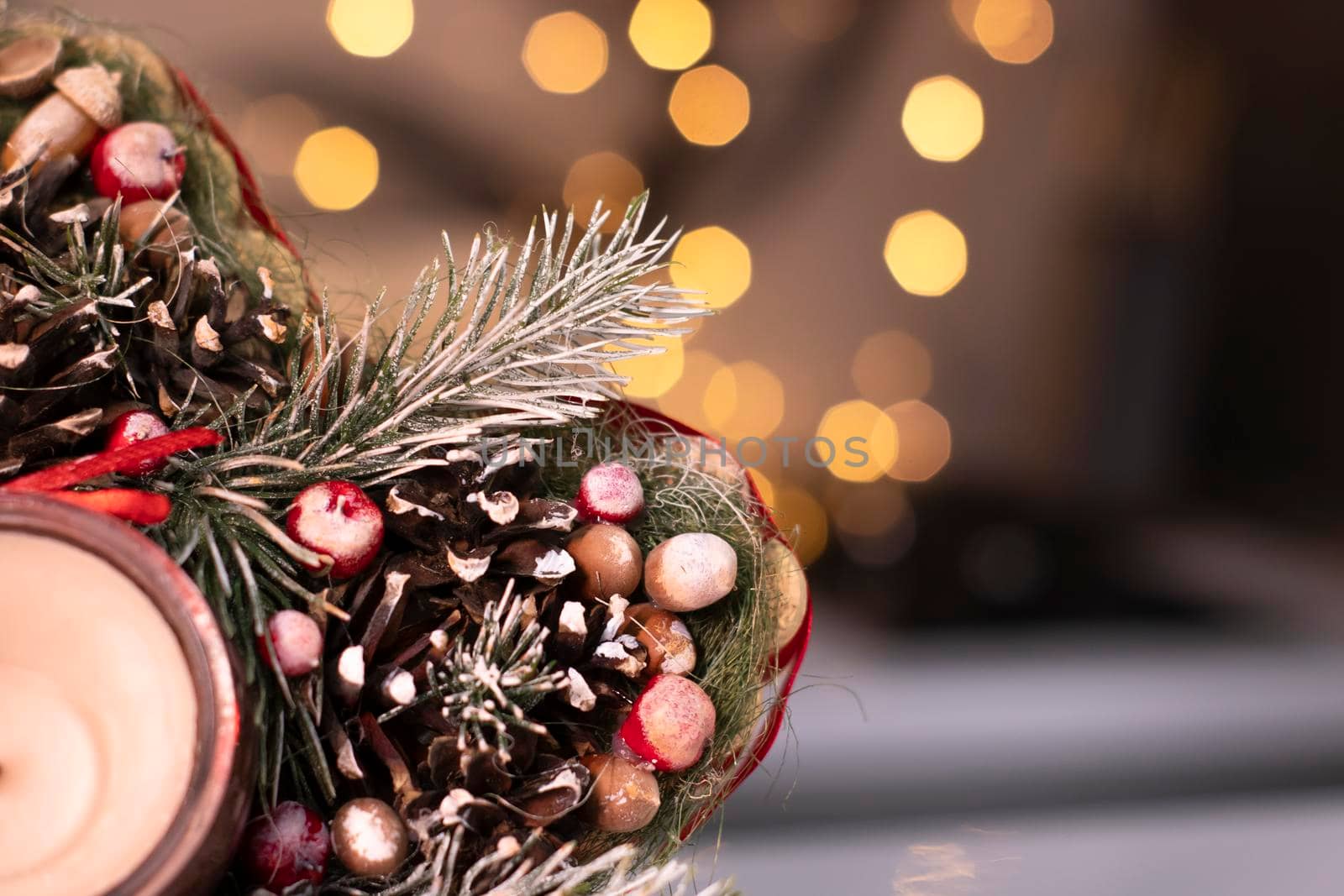 Christmas decor star-shaped made of tree branch with new years toys on it and a candle in it.