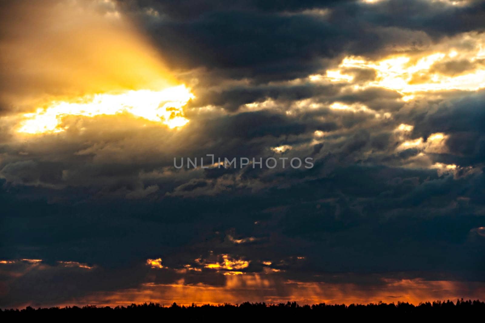 The heavenly light of the sun.Dramatic evening sky with clouds and rays of the sun.Sunlight at evening sunset or morning dawn.Panoramic view of the blue sky with clouds in motion.Heaven sunset