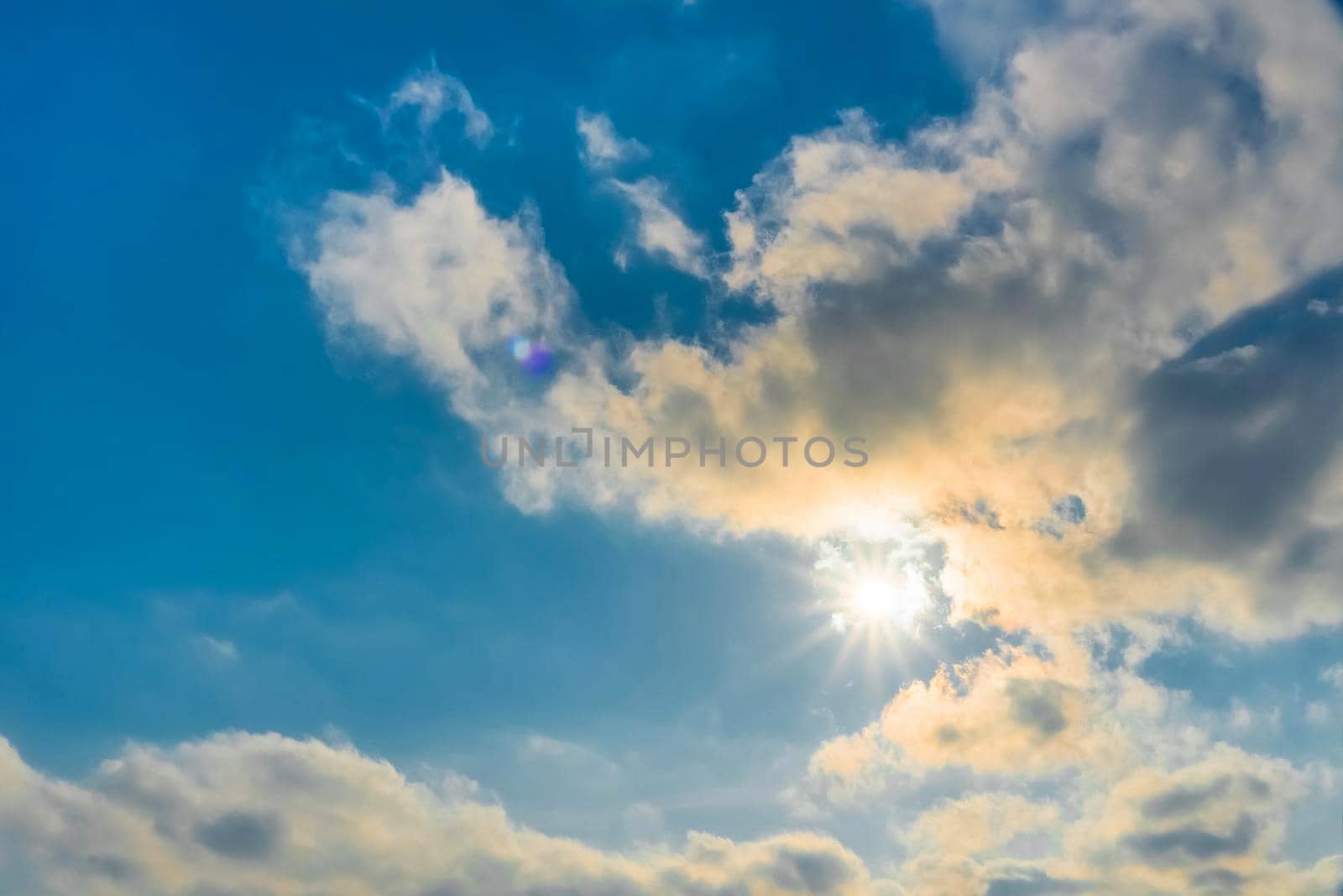 The rays of the sun break through the clouds.Blue sky with white feather clouds. Panoramic view of the blue sky with clouds in motion.Nice weather with clear skies. Panorama of the sky.Heavenly Light by YevgeniySam