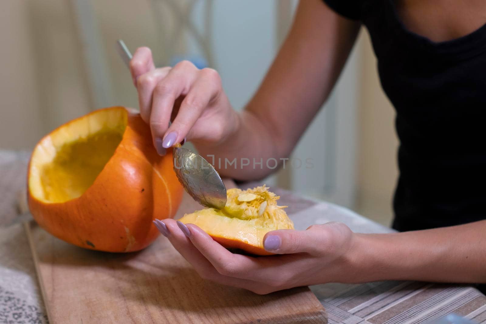 the process of making a Halloween pumpkin. cleansing of seeds by a brunette girl. horror theme and Hallowe'en.