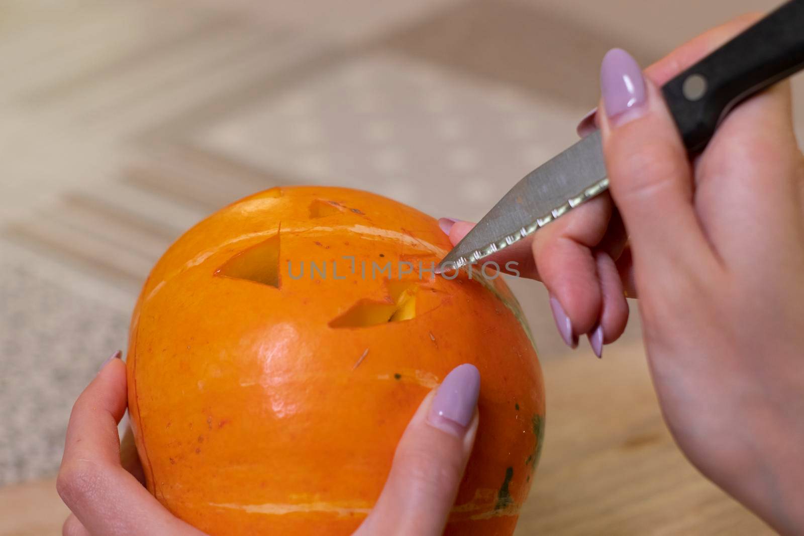 the process of making a Halloween pumpkin. cutting out the mouth. horror theme and Hallowe'en by oliavesna