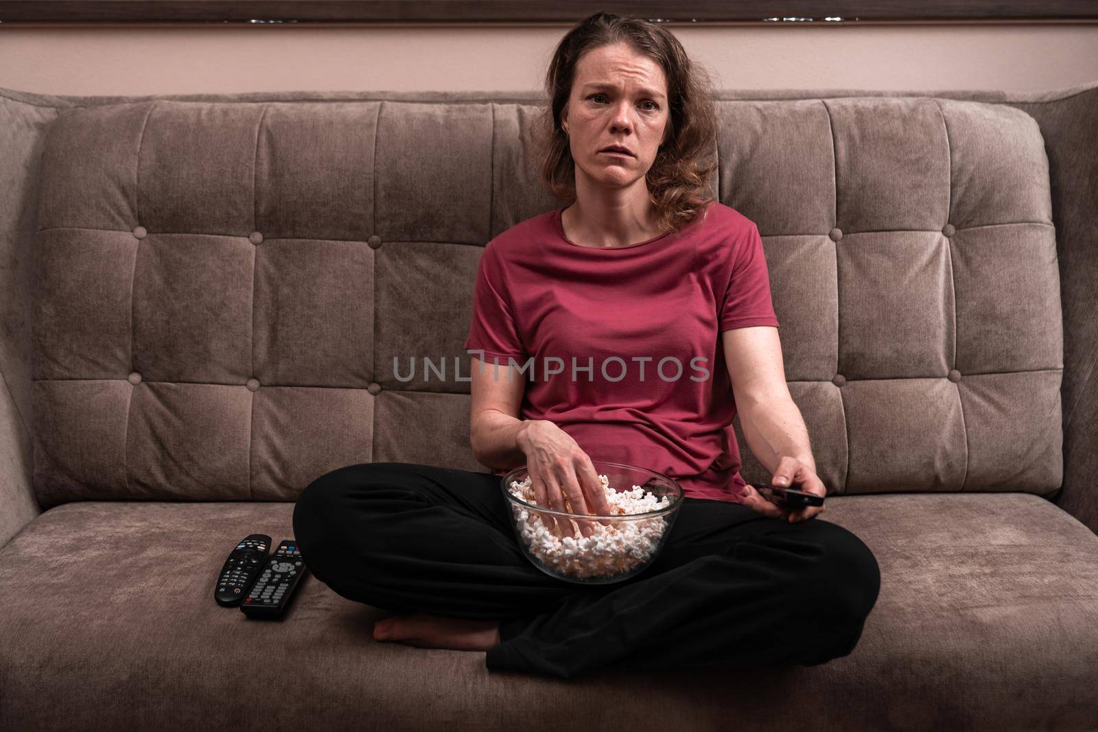 emotions when watching TV at home with popcorn. sadness and compassion by Edophoto