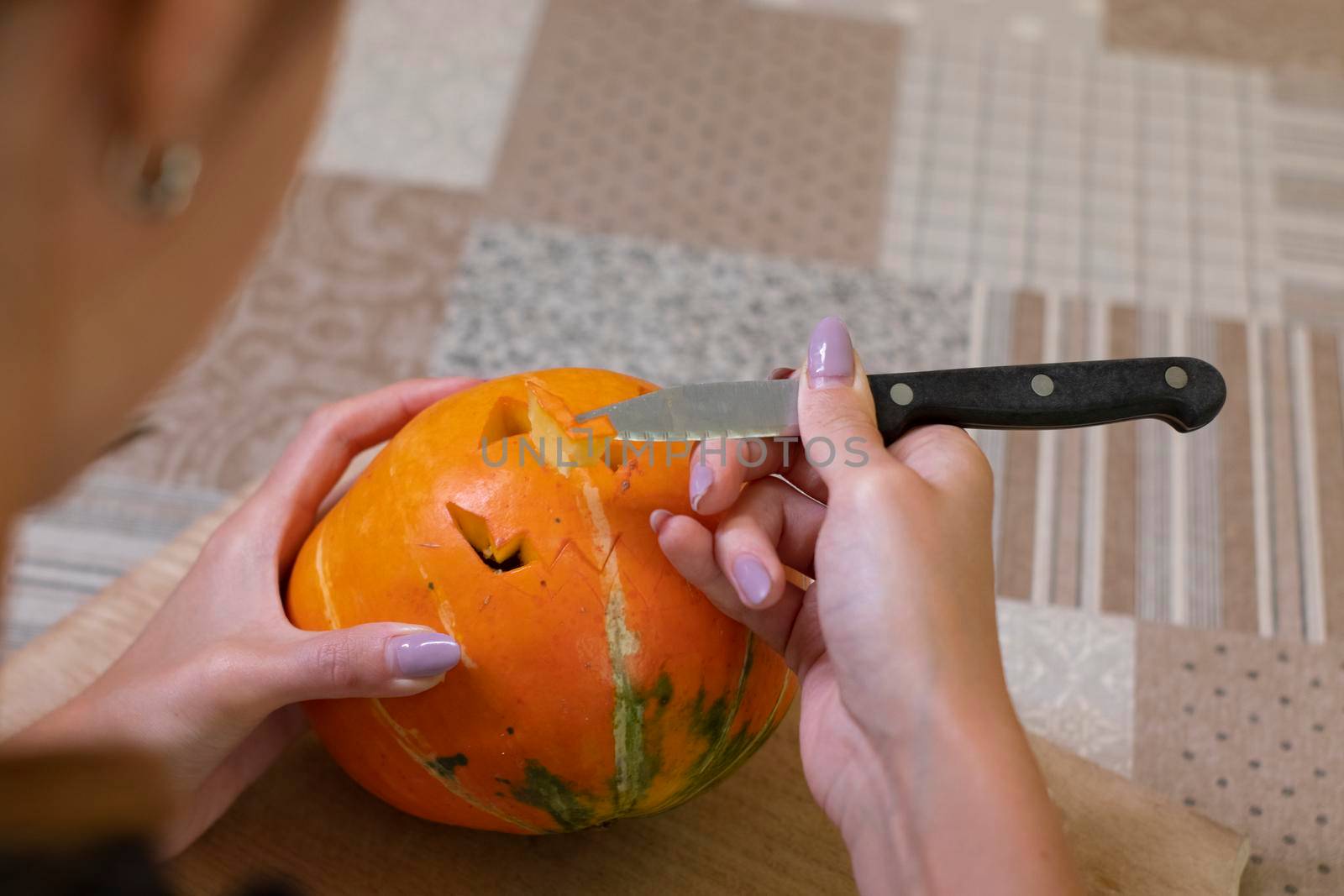 the process of making a Halloween pumpkin. cutting out the mouth. horror theme and Hallowe'en.