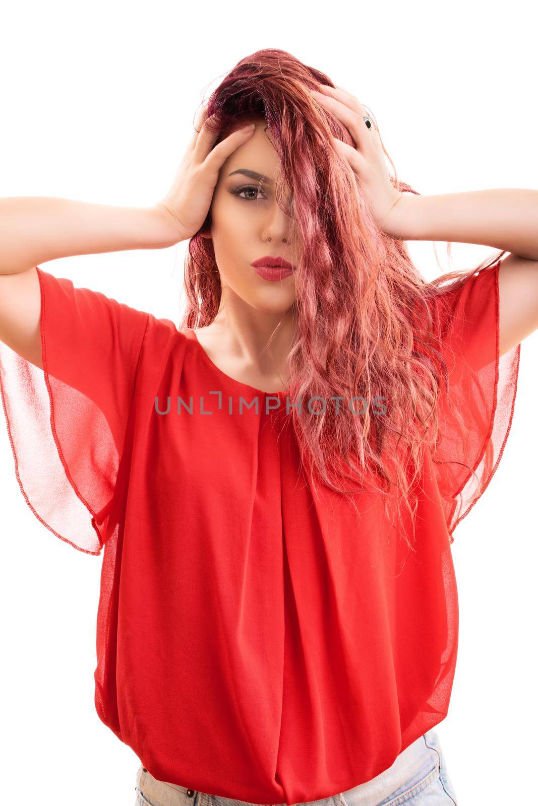 Close up of a beautiful redhead woman with long wavy hair over one side of her face sending a kiss to the camera, isolated on white background. Summer, enjoying concept.