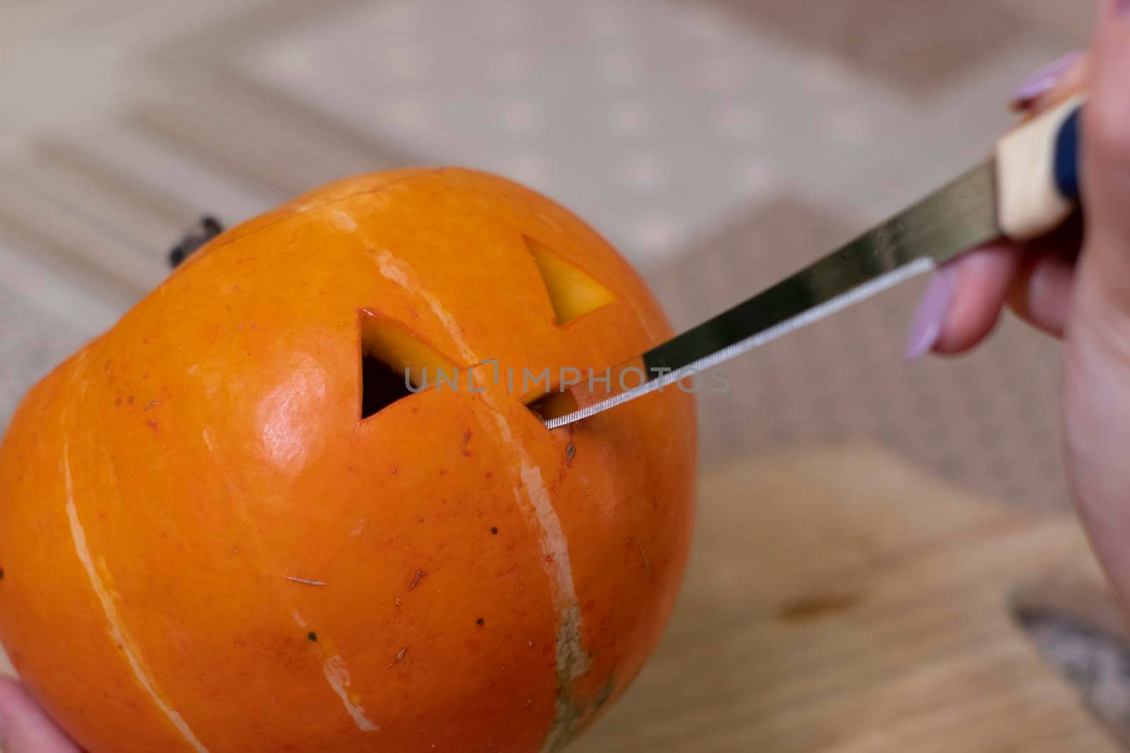 the process of making a Halloween pumpkin. cutting nose. horror theme and Hallowe'en.